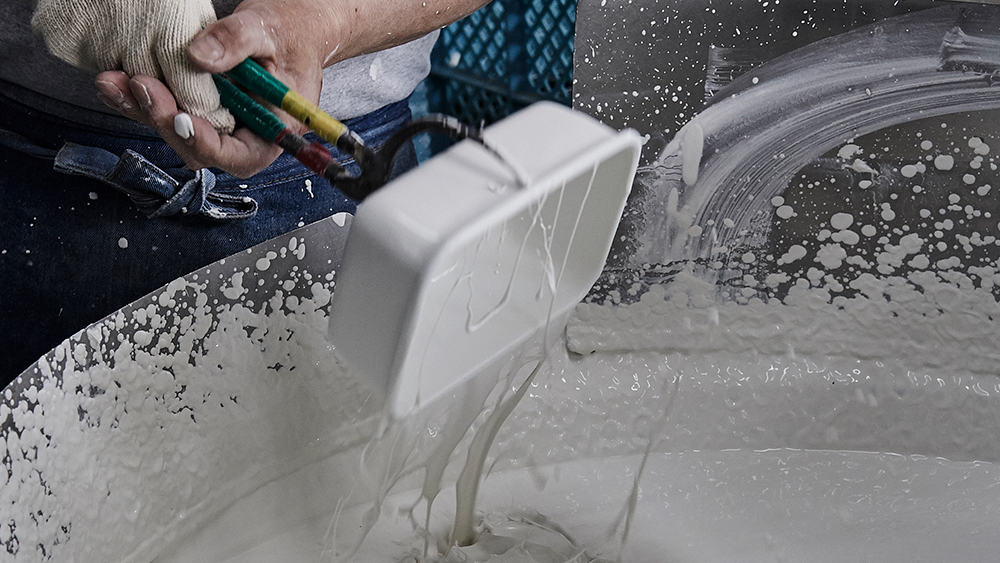 Applying the glaze to the molded metal Photo: Noda Horo