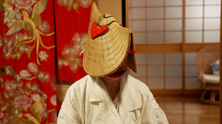 Koike wearing Hikosazukin hood and low-brimmed straw hats