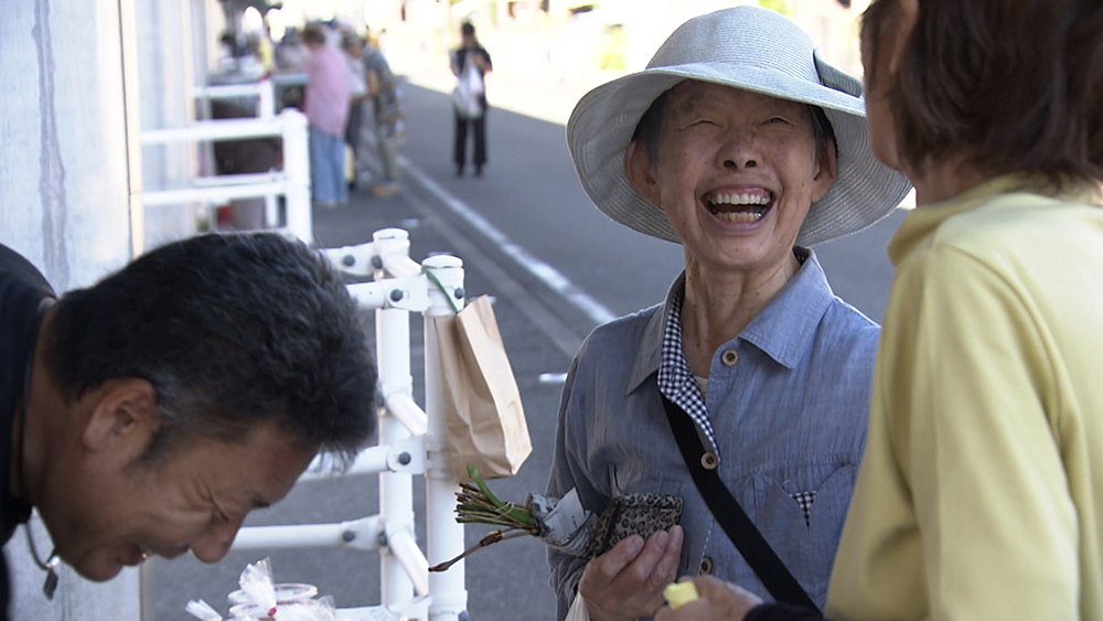 冗Regular customers share a joke with the stallholder.