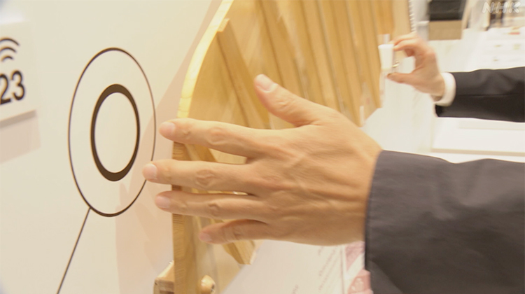Mizuguchi using a music box to experience the expansion of sound on the soundboard.