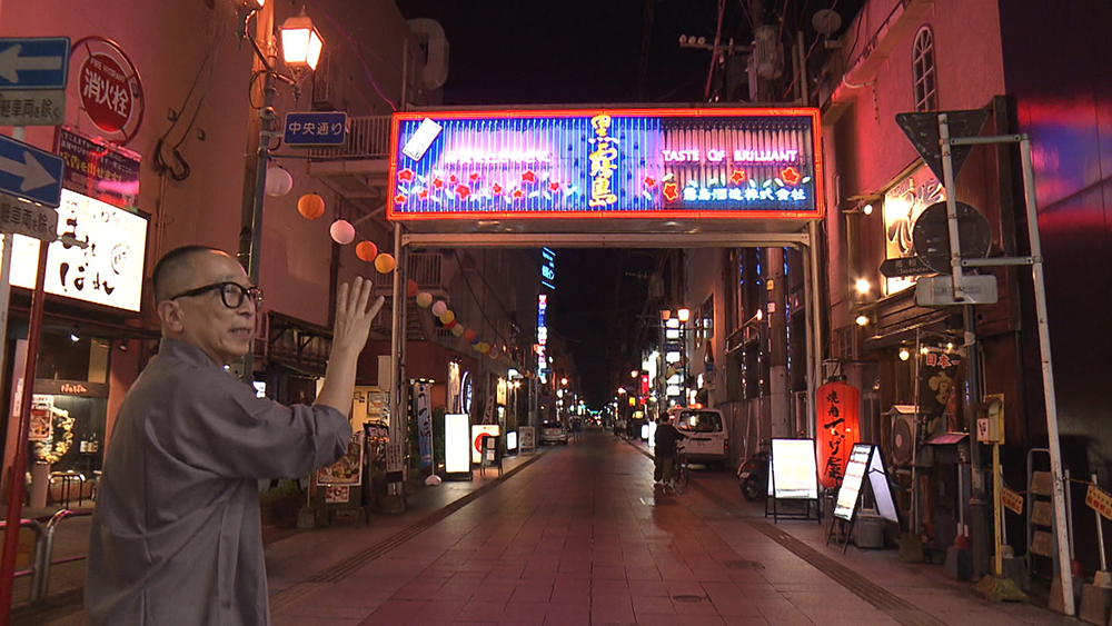 Sato passes beneath Nishitachi’s neon gate into another dimension.