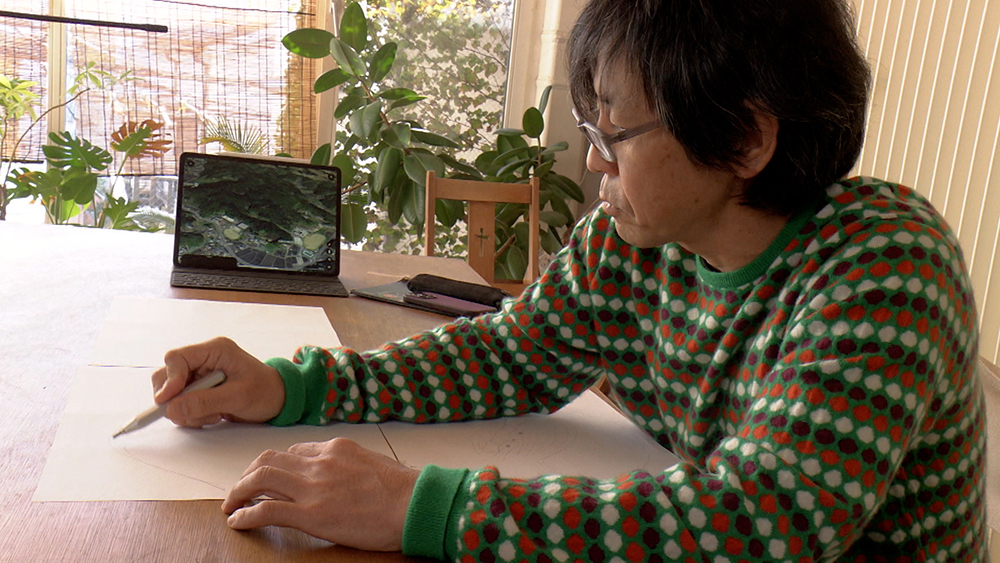 Photo: Tsukamoto sketches the topography around an ice chamber.